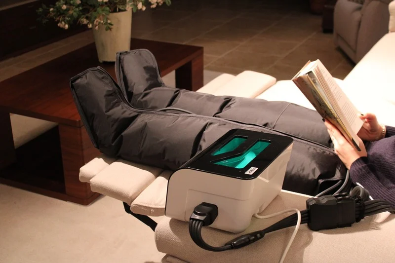 Presoterapia en posición lateral mientras una persona lee estirada en el sofá